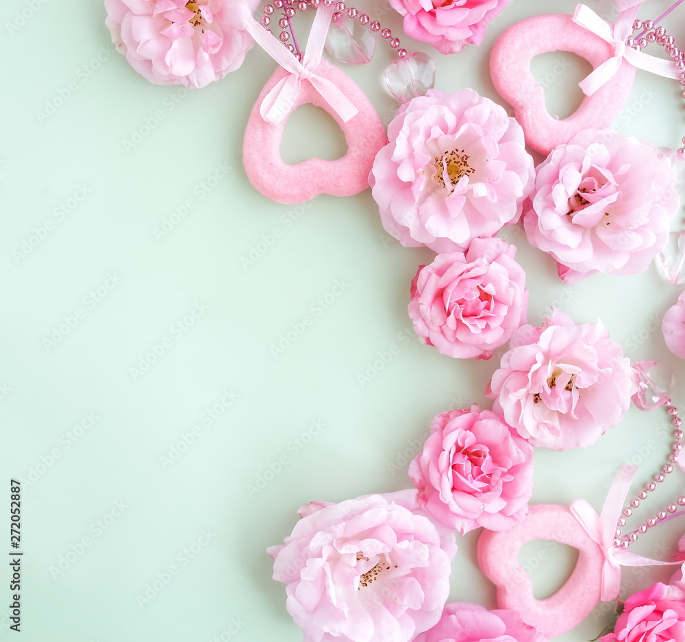 Flowers composition background. beautiful pale pink roses  and hearts decor on pale mint background.Valentines day concept, wedding.Top view.Copy space
