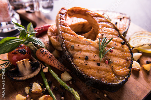 Canvas Print Grilled salmon fish with seasoning and various vegetables on cutting board