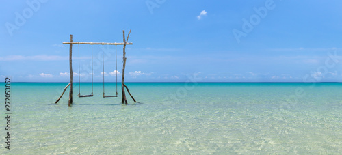 Tropical sea and blue sky on sunny day with wooden swings. © Petch A Ratana