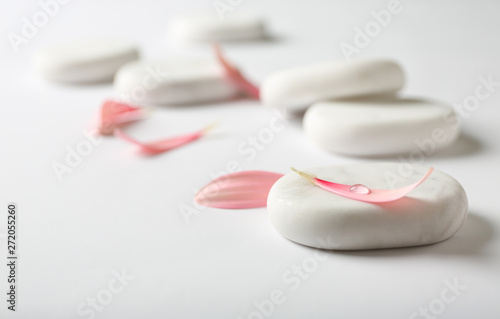Canvas Print Spa stones and flower petals on white background. Space for text