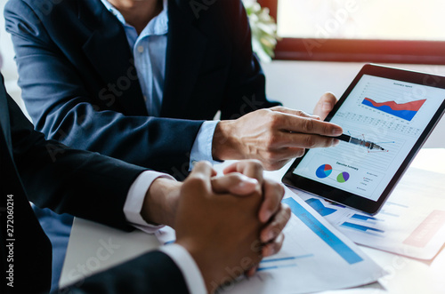 partner business man investor team brainstorming and planning about financial statistics chart information in mobile tablet together in meeting room at office, finance, investment and digital concept photo