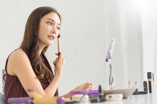 Attractive Woman is looking in the makeup mirror. photo