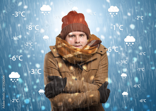 Young man freezing in warm clothing with weather condition and forecast concept
 photo