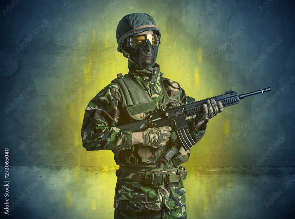 Fototapeta premium Hazard, menace soldier in a ruined crumbly building with arms on his hand 