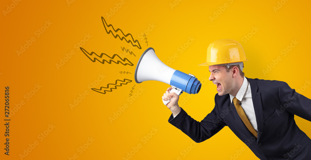 Fototapeta premium Young architect constructor yelling with megaphone and copyspace