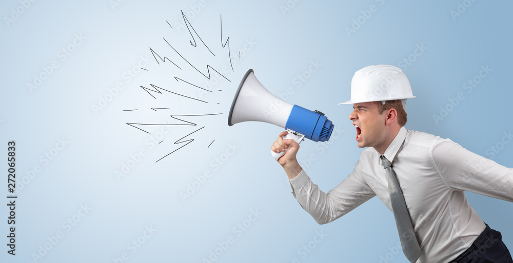 Fototapeta premium Young architect constructor yelling with megaphone and copyspace 
