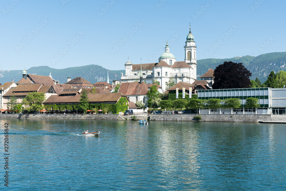 city of Solothurn with the river Aare panorama cityscape view of the old town and a fishing boat heading downstream
