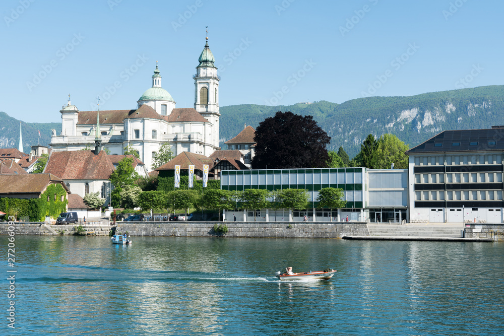 city of Solothurn with the river Aare panorama cityscape view of the old town and a fishing boat heading downstream