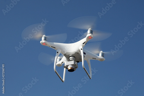 Fototapeta Naklejka Na Ścianę i Meble -  Drone on blue sky background. Remote control quadrocopter with camera for photography. Flying robot.