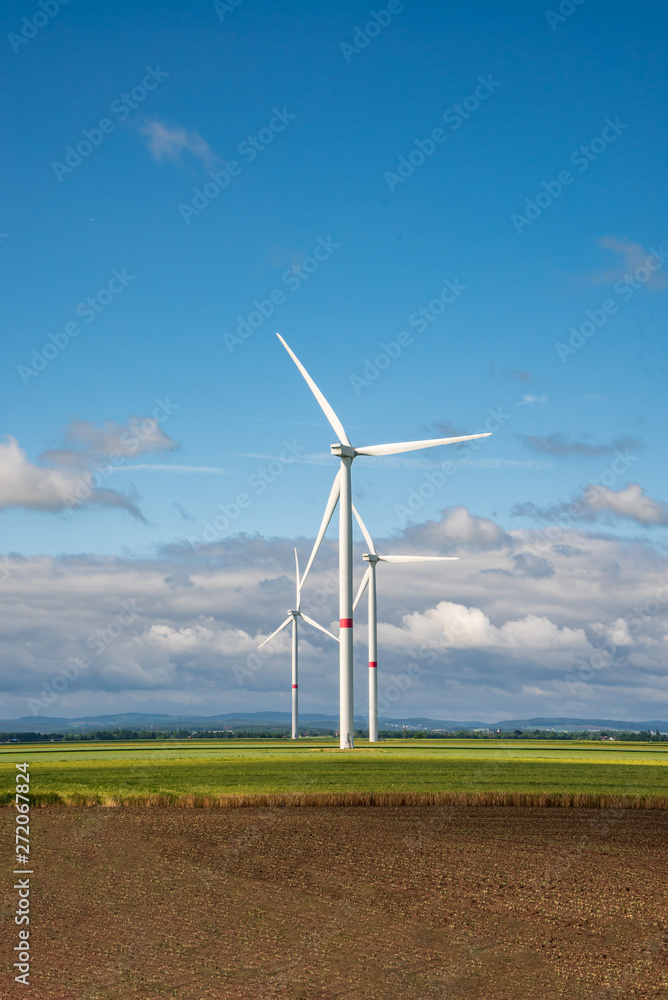 Wind turbine on clear field in sunshine and clouds Wind turbine on clear field in sunshine and clouds