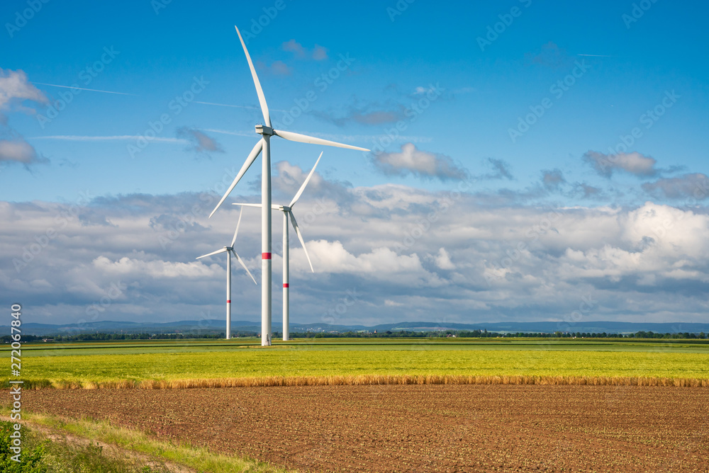 Wind turbine on clear field in sunshine and clouds Wind turbine on clear field in sunshine and clouds