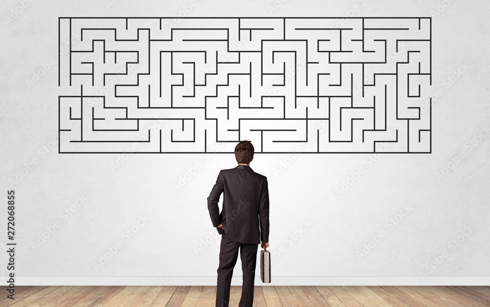 Businessman in doubt looking to a maze and searching the way out Businessman in doubt looking to a maze and searching the way out