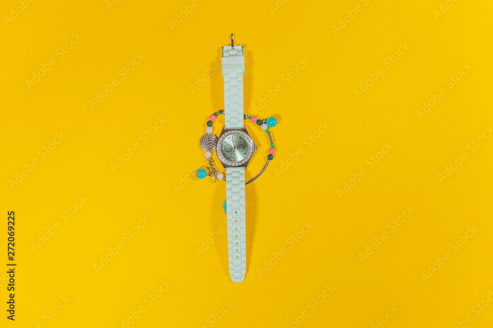 Fototapeta premium A white watch is laying in the middle of a bracelet on a white surface