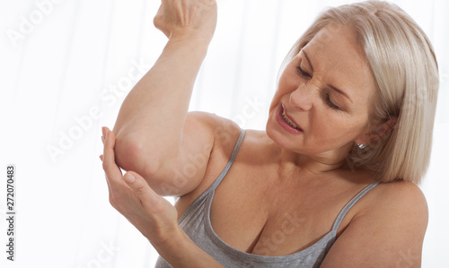 Woman with pain in arm, elbow. Pain in the human body, health care concept.
