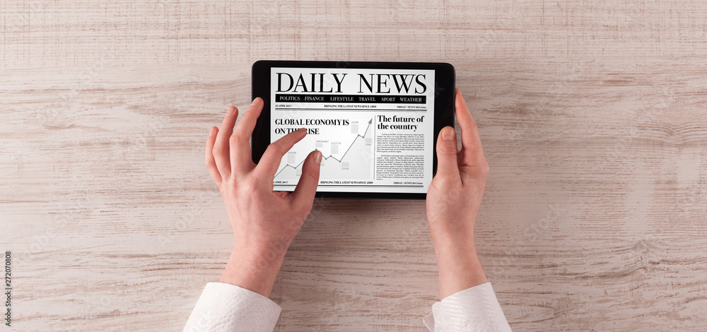 Hand with tablet reading news on tablet
Hand with tablet reading news on tablet