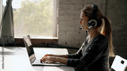 Focused mature woman working in call center using headset