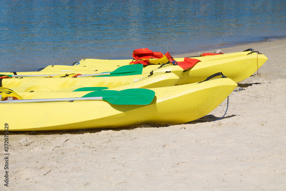 colorful kayak with paddle on a tropical beach in sunny summer colorful kayak with paddle on a tropical beach in sunny summer