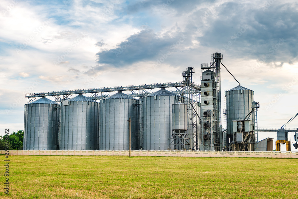 agro-processing plant for processing and silos for drying cleaning and storage of agricultural products, flour, cereals and grain with beautiful clouds agro-processing plant for processing and silos for drying cleaning and storage of agricultural products, flour, cereals and grain with beautiful clouds