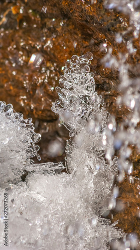 Panorama Close up of crystalline ice and brown rock covered with shiny frozen water