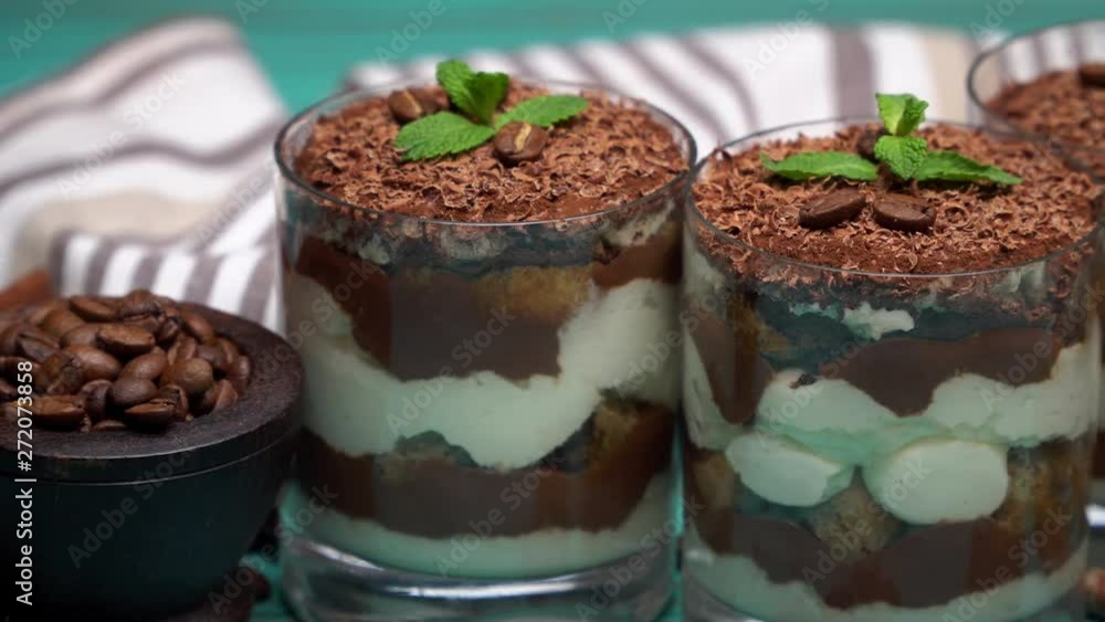 Classic tiramisu dessert in a glass on blue wooden background Classic tiramisu dessert in a glass on blue wooden background
