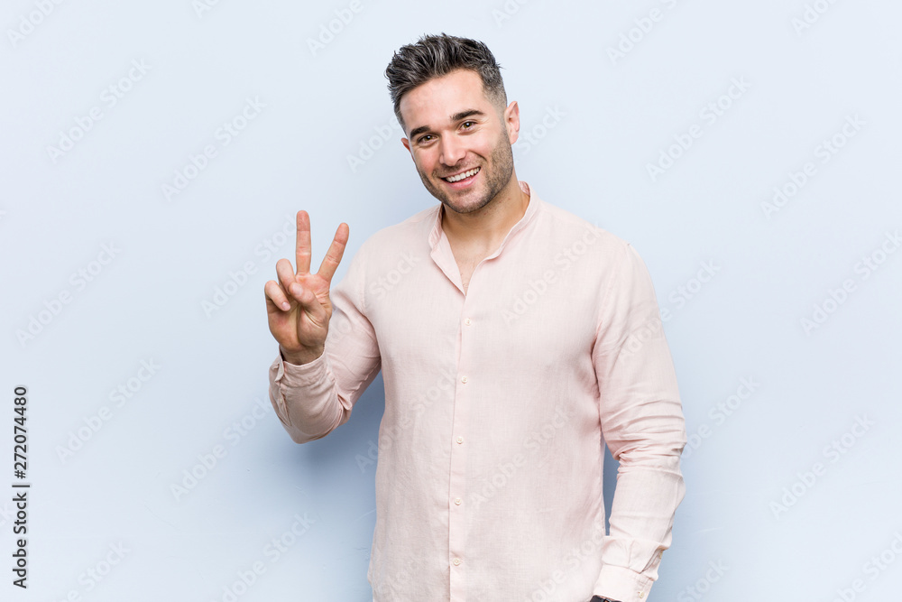 Young handsome cool man showing victory sign and smiling broadly. Young handsome cool man showing victory sign and smiling broadly.