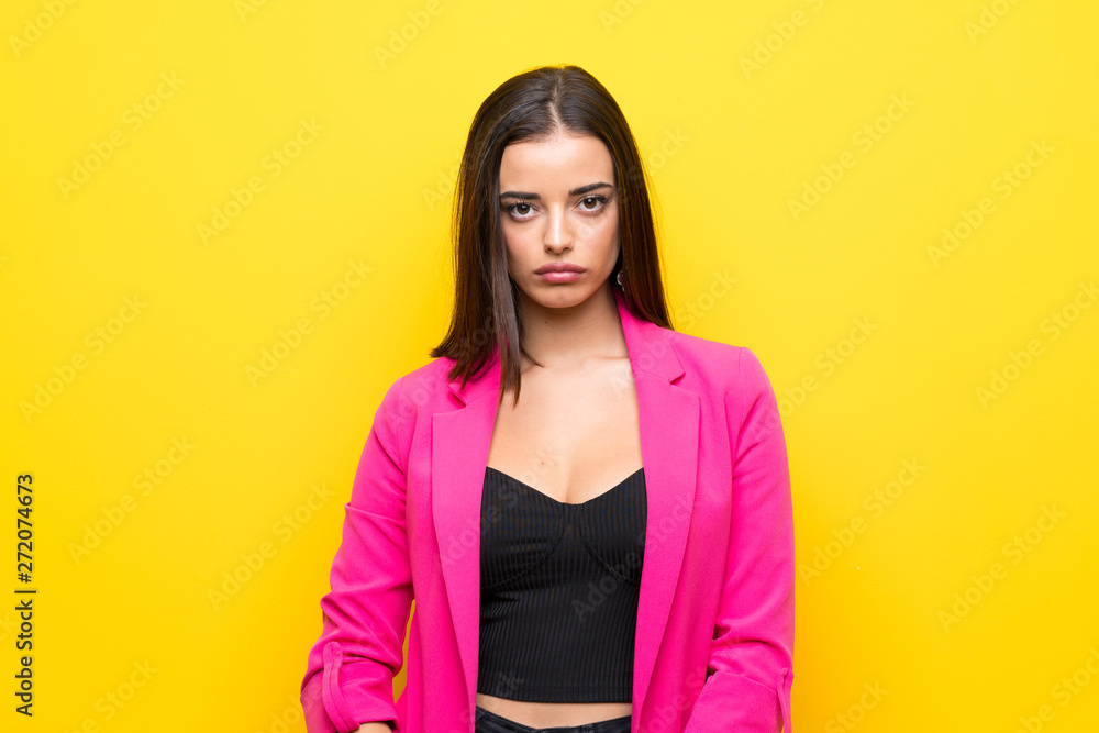 Fototapeta premium Young woman over isolated yellow background with sad and depressed expression