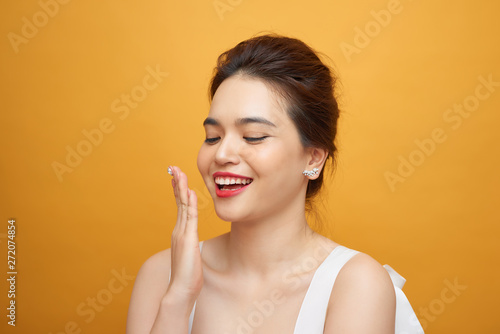 Surprised model woman isolated on yellow background. Laughing girl with red lips.
