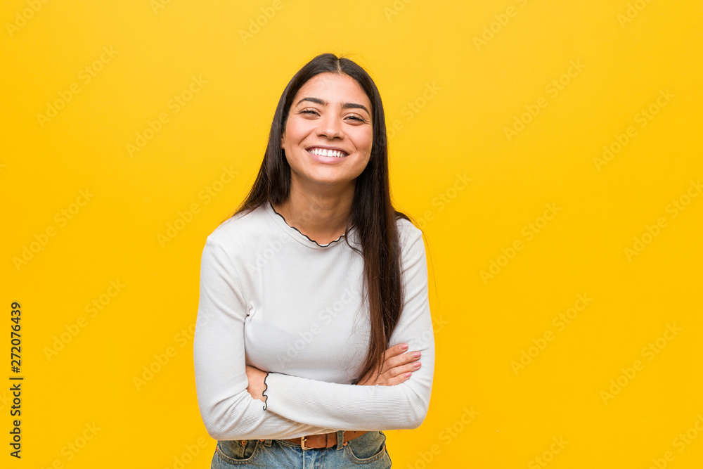 Young pretty arab woman against a yellow background laughing and having fun. - obrazy, fototapety, plakaty 