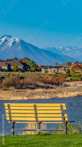 Panorama frame Bench with a scenic view of lake and snow capped mountain against blue sky