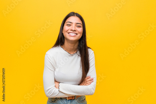 Young pretty arab woman against a yellow background laughing and having fun.