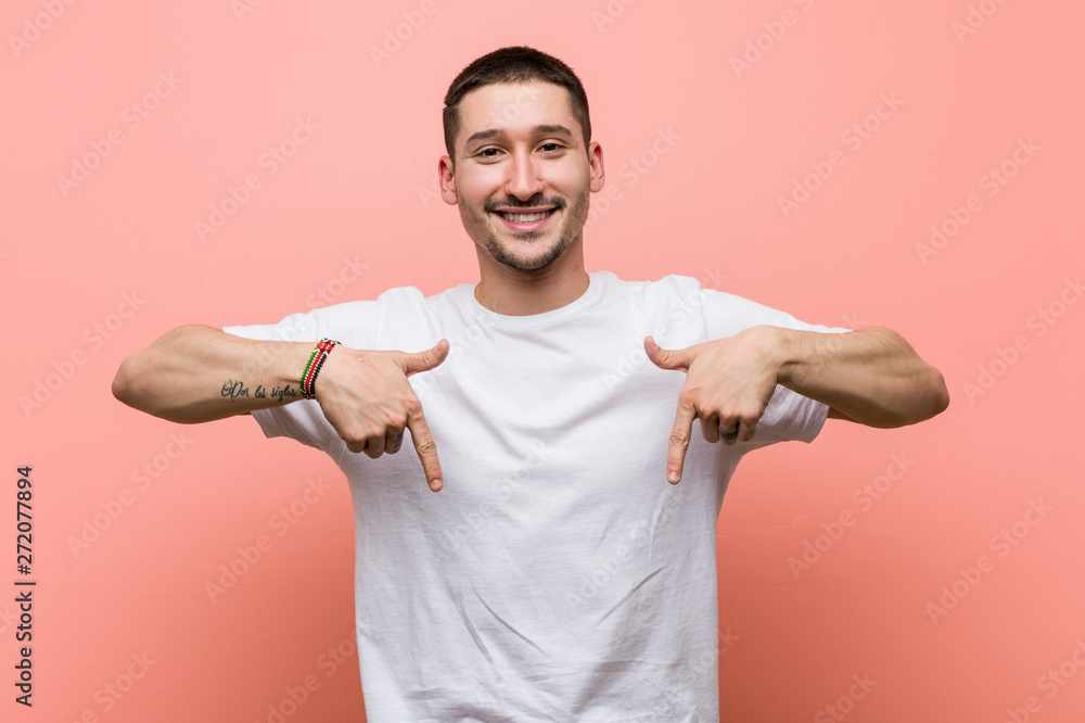 Young casual man points down with fingers, positive feeling. Young casual man points down with fingers, positive feeling.