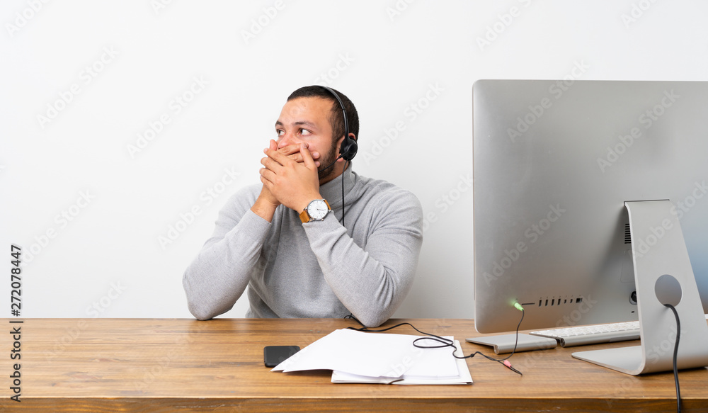 Telemarketer Colombian man covering mouth and looking to the side Telemarketer Colombian man covering mouth and looking to the side