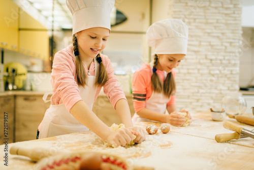 Little girls chefs crumple the dough, funny bakers