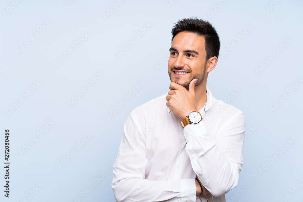 Handsome young man over isolated blue background looking to the side Handsome young man over isolated blue background looking to the side