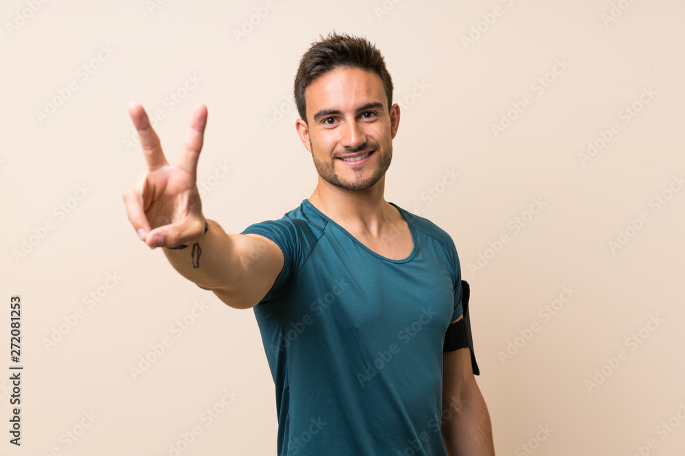 Handsome sport man over isolated background smiling and showing victory sign Handsome sport man over isolated background smiling and showing victory sign