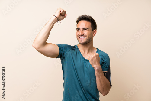 Fototapeta Naklejka Na Ścianę i Meble -  Handsome sport man over isolated background celebrating a victory