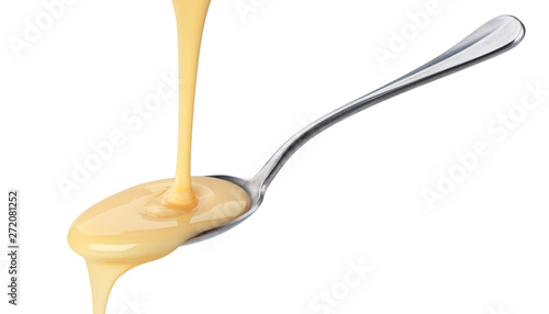 Pouring condensed milk isolated on white background