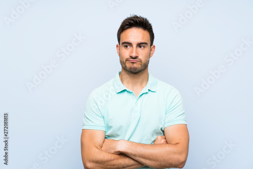 Handsome young man over isolated background with confuse face expression