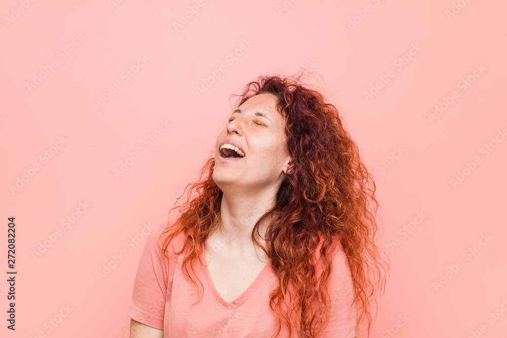 Young natural and authentic redhead woman relaxed and happy laughing, neck stretched showing teeth. Young natural and authentic redhead woman relaxed and happy laughing, neck stretched showing teeth.