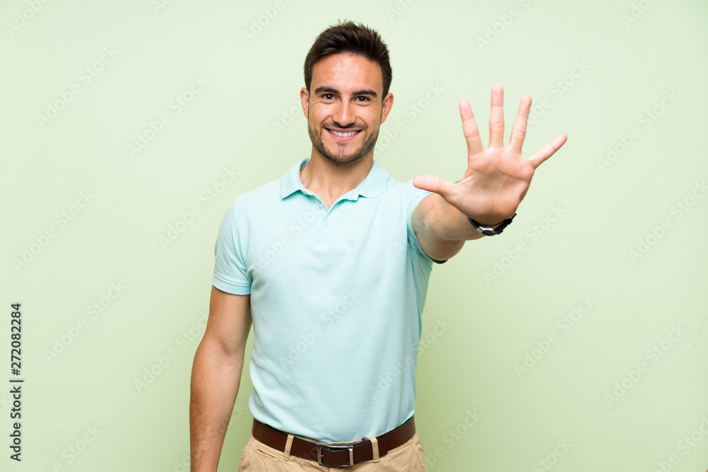 Fototapeta premium Handsome young man over isolated background counting five with fingers