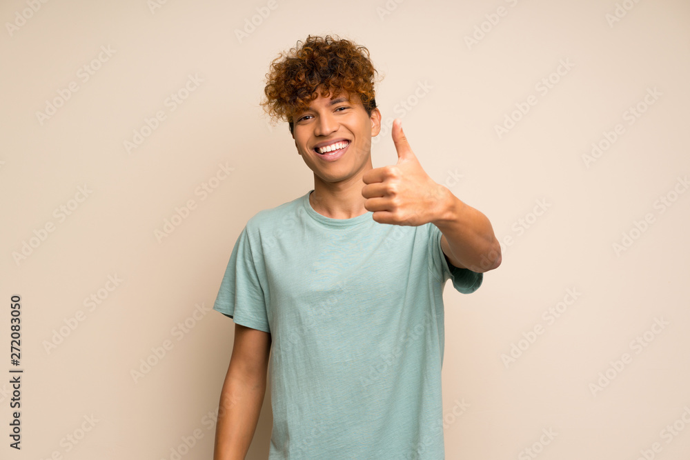 African american man with green shirt with thumbs up because something good has happened African american man with green shirt with thumbs up because something good has happened