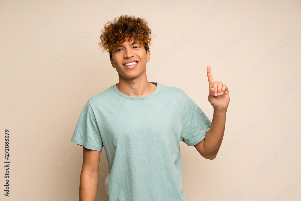 African american man with green shirt showing and lifting a finger in sign of the best African american man with green shirt showing and lifting a finger in sign of the best