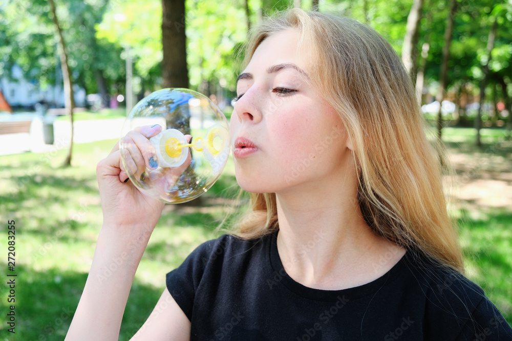 Attractive teen caucasian girl with blond hair blowing bubbles. Attractive teen caucasian girl with blond hair blowing bubbles.