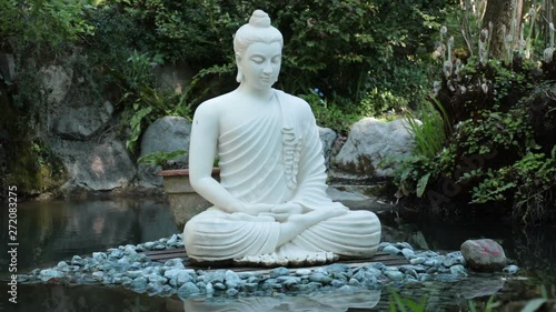 White buddha in the nature. Buddhist statue - yoga concept
