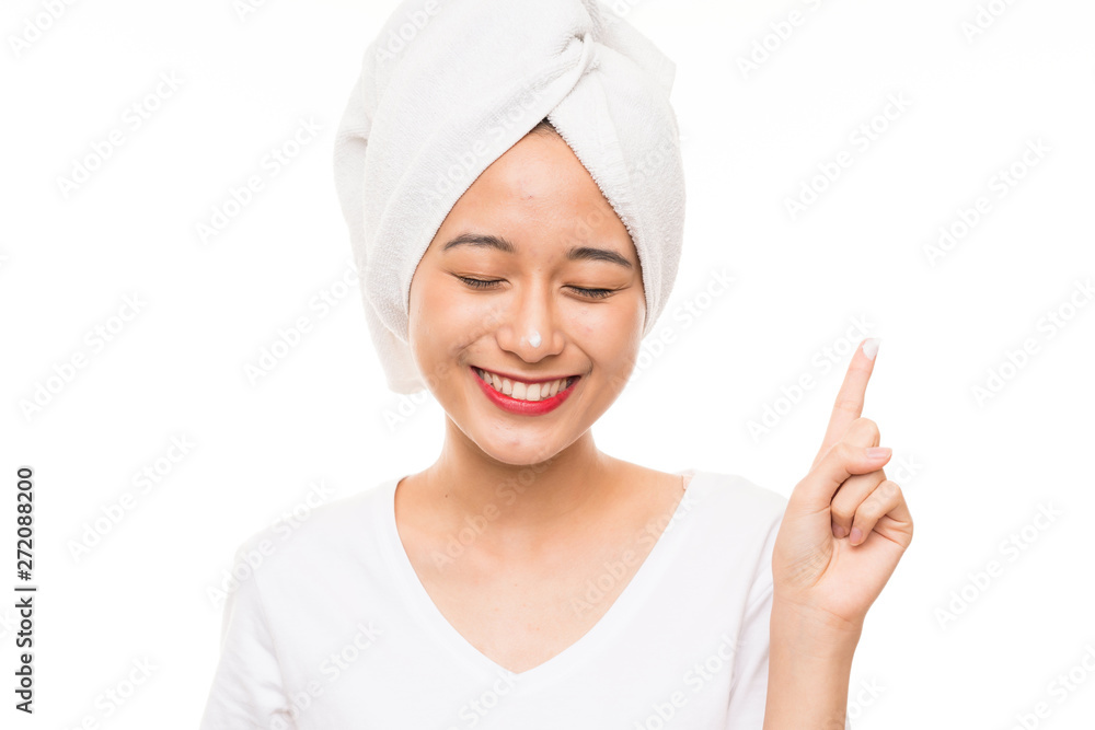 Asian young woman over isolated background with moisturizer