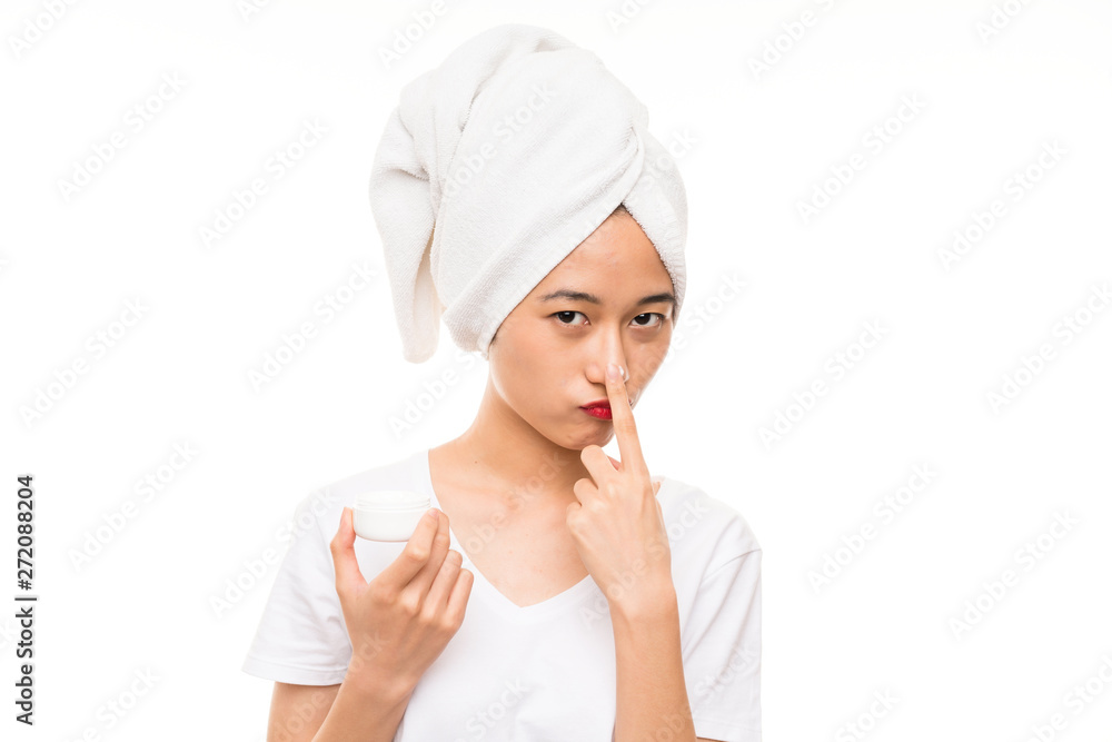 Asian young woman over isolated background with moisturizer Asian young woman over isolated background with moisturizer