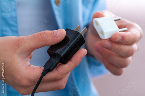 Person using an adapter and phone charger photo