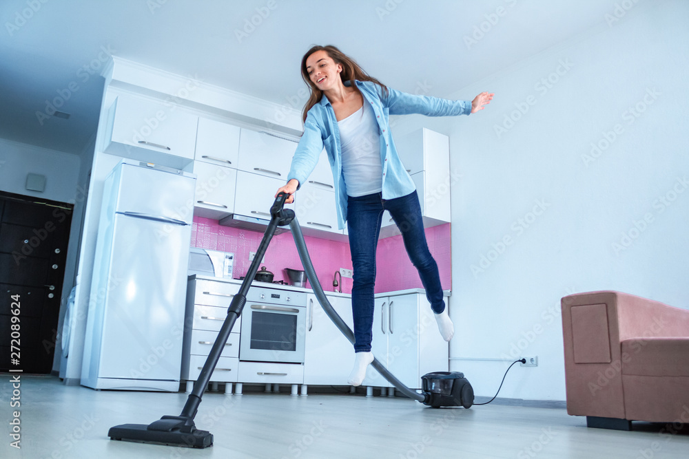 Young attractive woman vacuuming house with vacuum cleaner. Housekeeping  and spring cleaning. Clean concept. Happy, funny cleaning Stock Photo |  Adobe Stock