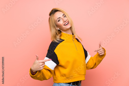 Young blonde woman over isolated pink background proud and self-satisfied