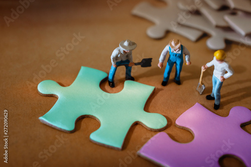Teamwork, Business Strategy, Connection, Partnership and Team Collaborate Concept.  Group of Miniature Worker Working on Jigsaw Puzzle